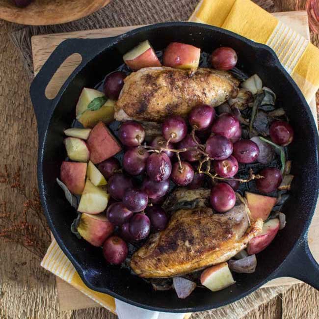 oven roasted chicken breast with grapes and apples on a skillet