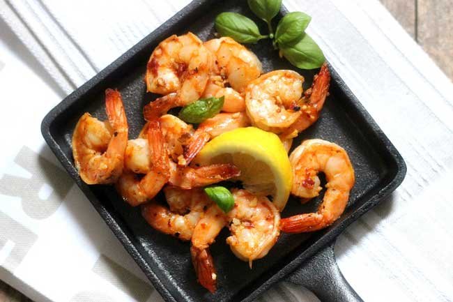 spicy sauteed shrimp and lemon on a skillet