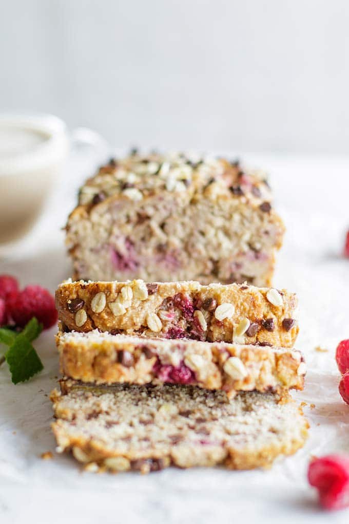 Gluten free banana bread with raspberries and dark chocolate chips cut into thick slices.